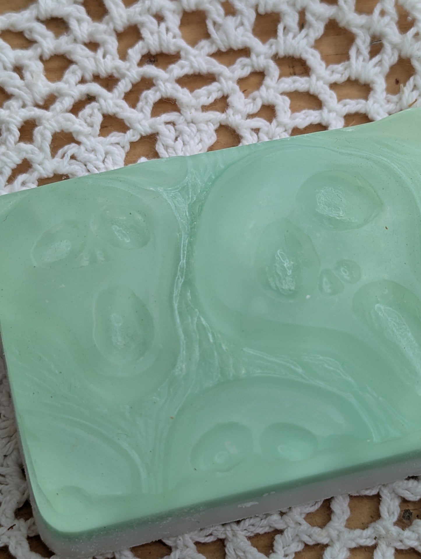 Green soap bar with embossed 'Screaming Ghost' design on a textured white surface