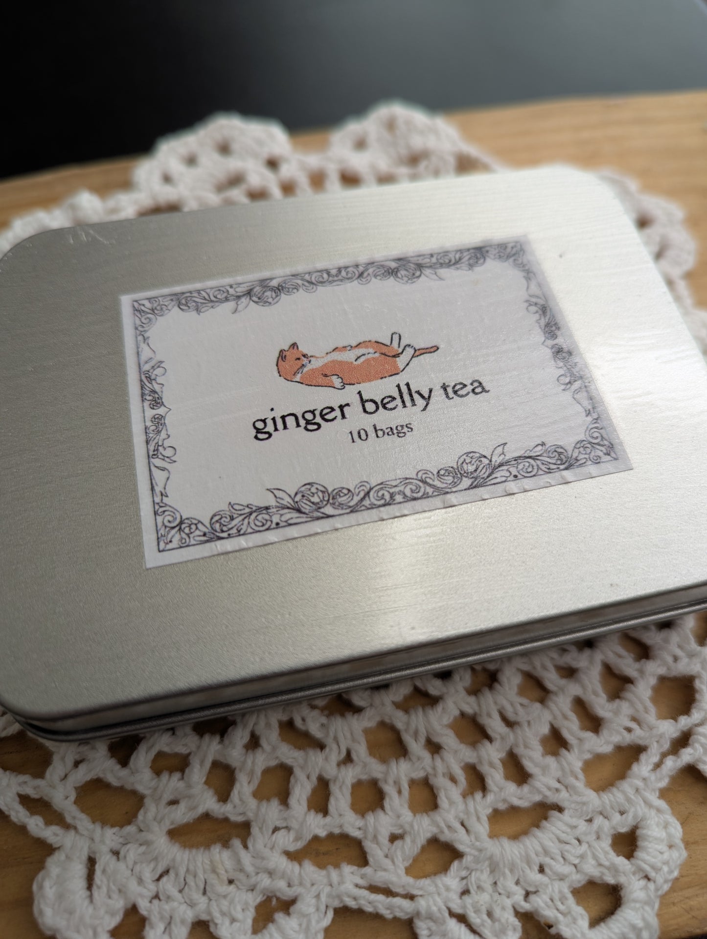 Ginger belly tea tin with label on a lace doily