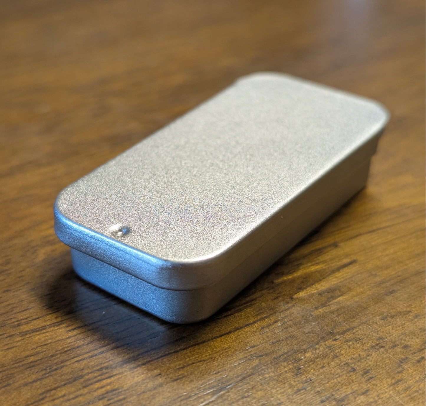 Silver rectangular metal tin on a wooden surface