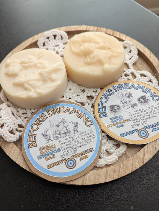 Two soap bars with 'Before Dreaming' labels on a wooden tray with doily
