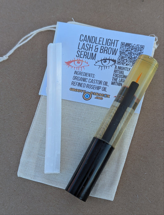 Candlelight Lash & Brow Serum with packaging on a brown surface