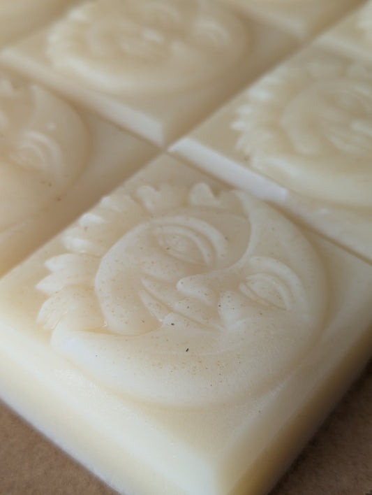 Close-up of a bar of soap with a sun and moon design on a brown background