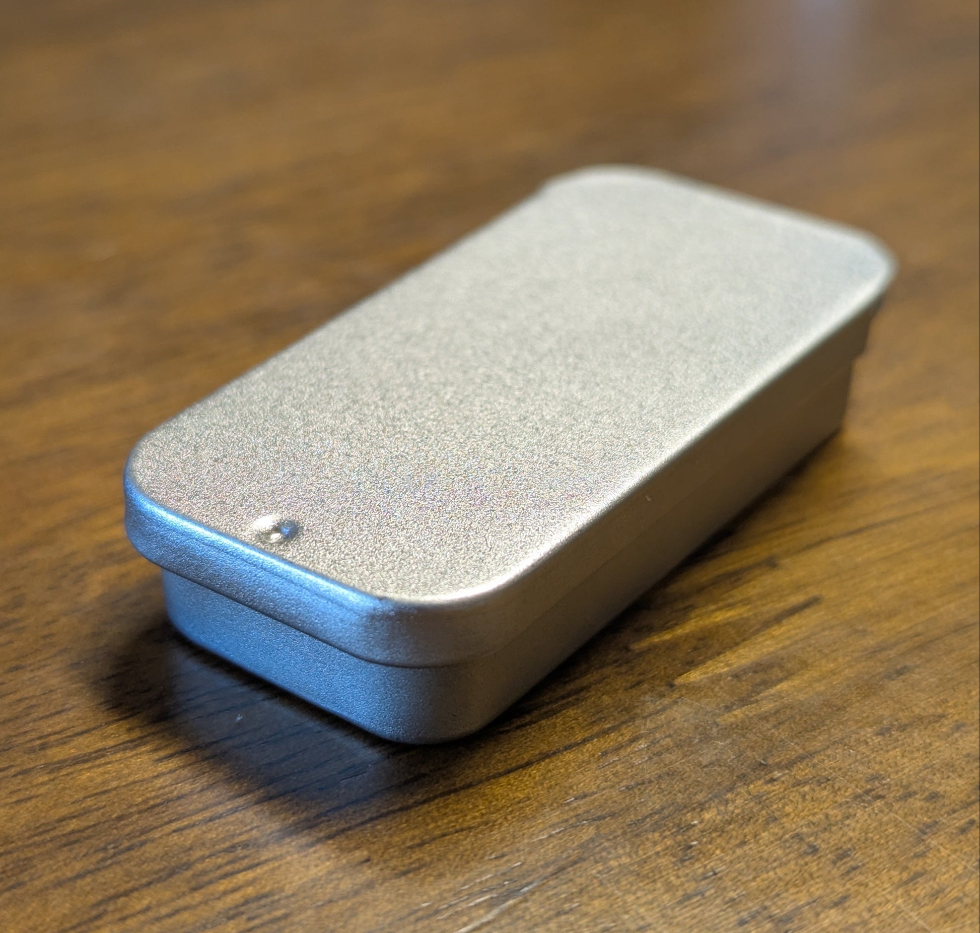 Silver rectangular metal tin on a wooden surface