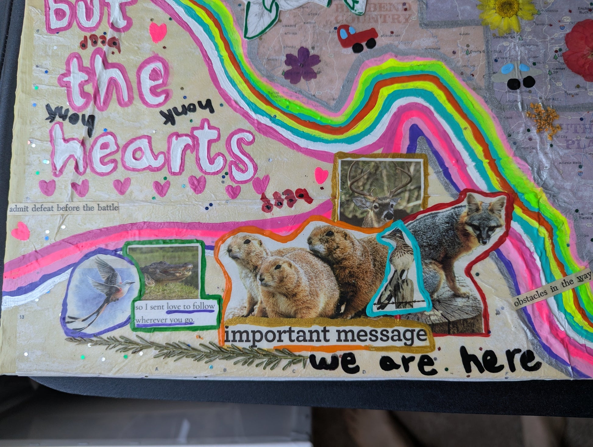 A colorful mixed-media collage board featuring animal cutouts, handwritten text, and rainbow accents on a beige background.