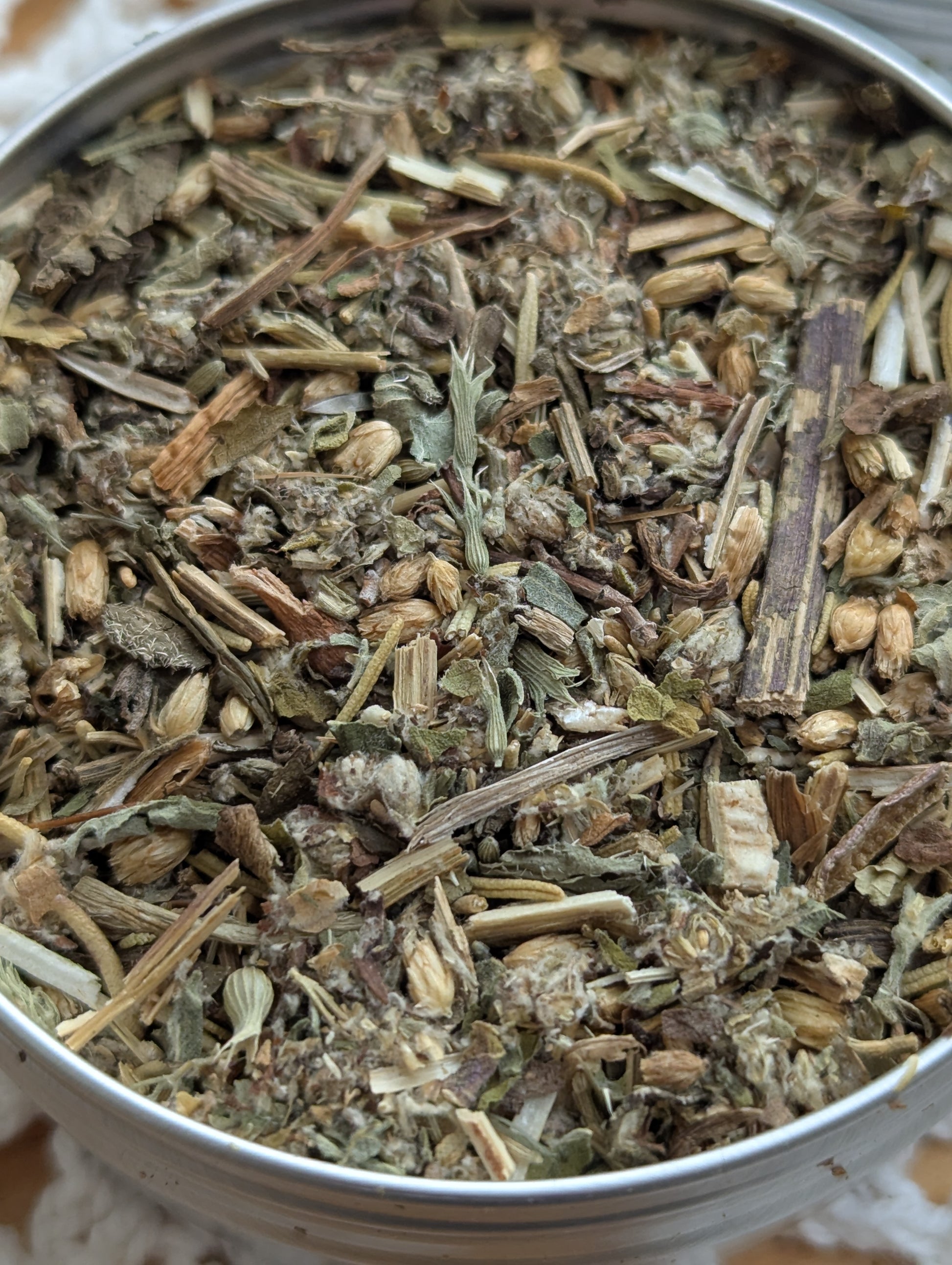 Close-up of dried herbs in a metal container